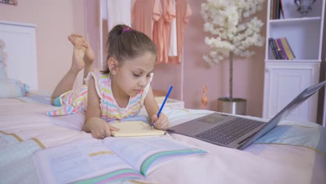 niña haciendo la tarea en la computadora portátil.