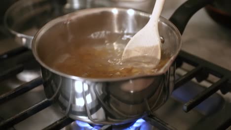 stirring pasta in pot of boiling water in slow motion