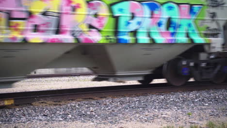 Close-Up-View-of-Cargo-Train-Traveling-on-Railroad-Tracks-in-Daylight