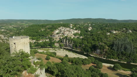 aerial flyby old watchtower towards balazuc village by ardèche river