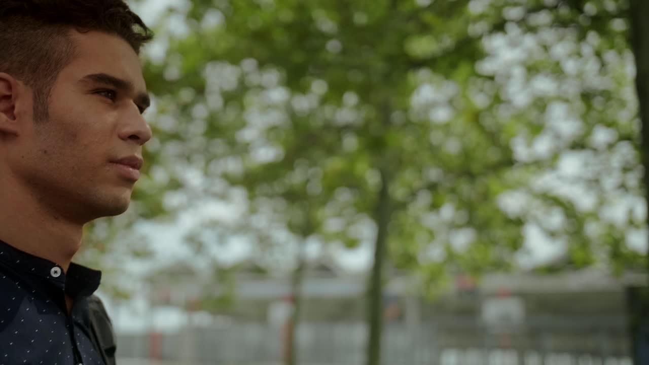 retrato de hombre de negocios bien vestido de un joven atractivo hombre de moda caminando en un día soleado por la mañana con un fondo urbano moderno en cámara lenta