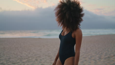 Mujer-Turista-Caminando-Por-La-Playa-En-Traje-De-Baño-Negro-Al-Atardecer-De-Verano.-Chica-Relajante