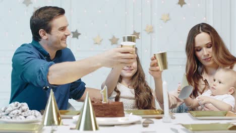 una familia sonriente celebrando su primer cumpleaños en una casa de lujo.