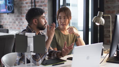 Young-Asian-man-and-Asian-woman-are-engaged-in-a-business-discussion-at-an-office-setting