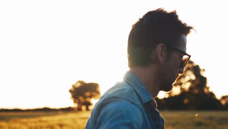 músico tocando la guitarra en el campo al atardecer