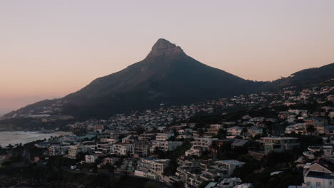 sunset drone shot in camps bay of lions head in cape town, south africa