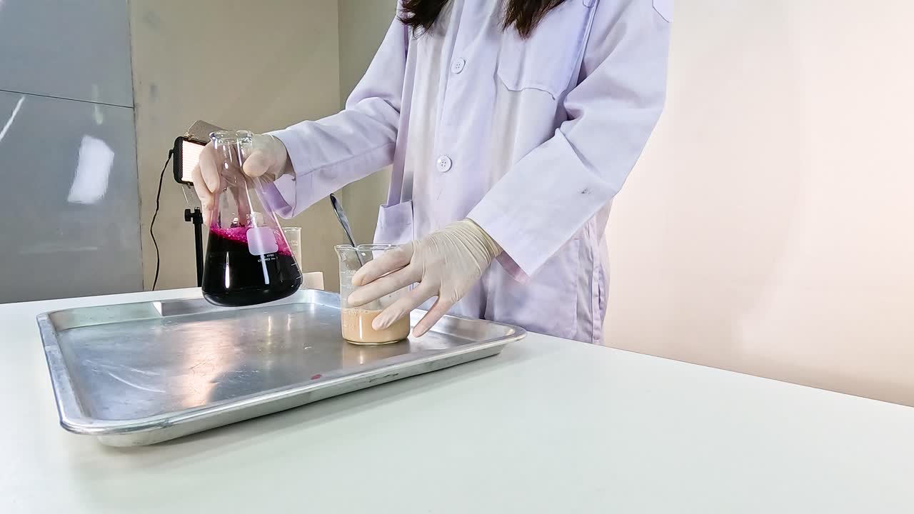 Scientist conducts a vibrant chemical experiment with beakers and colorful liquids on a lab table