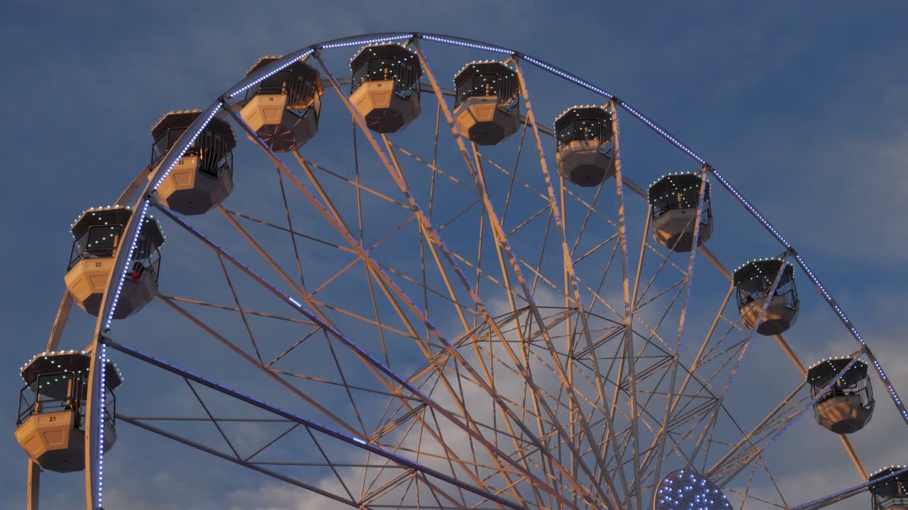Ferris wheel in action againts a blue sky.