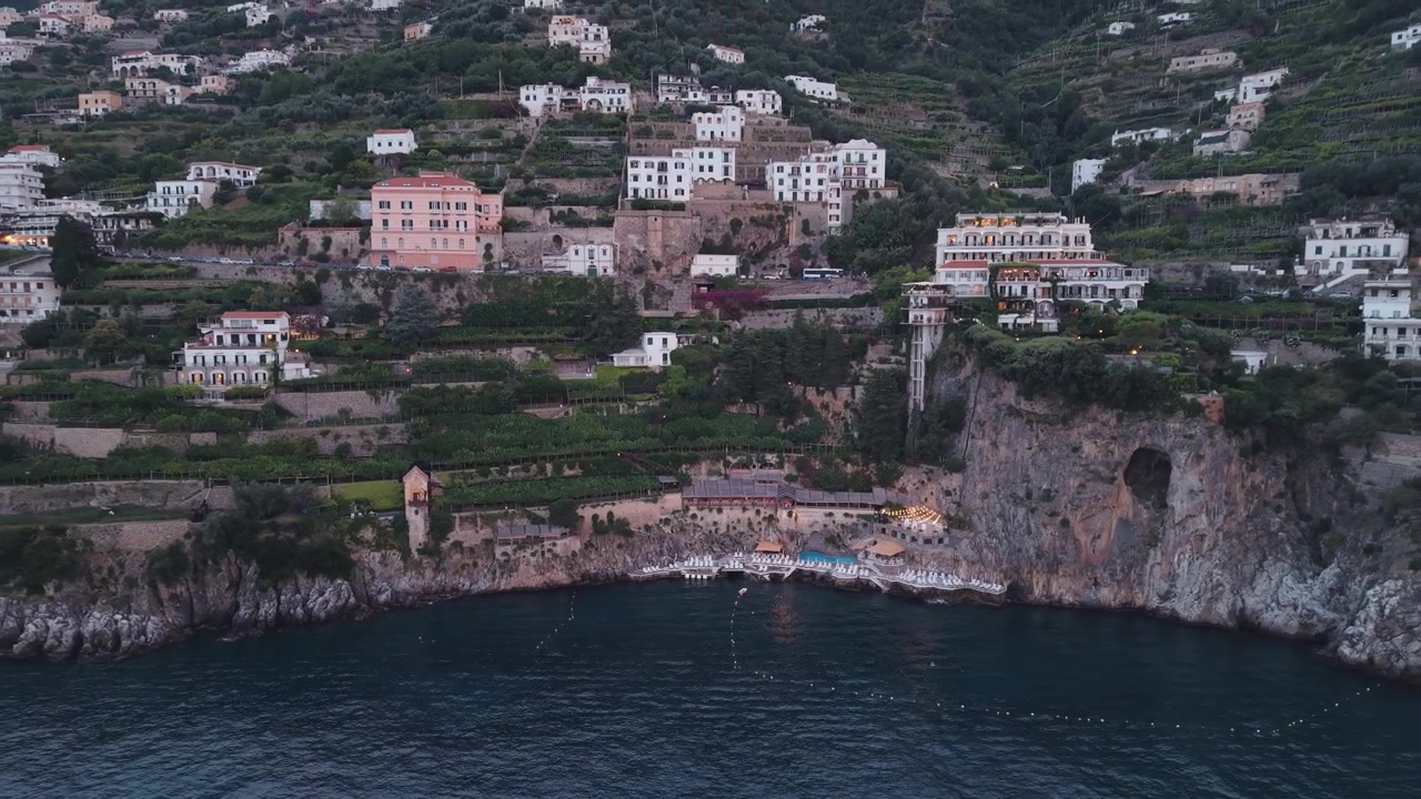 Ripresa aerea con drone in allontanamento che svela la Costiera Amalfitana, Italia