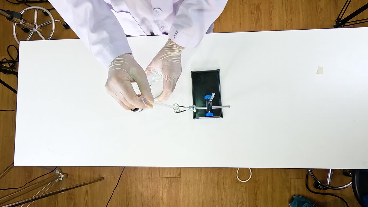 Scientist conducts a chemical reaction using lead nitrate and potassium iodide on a laboratory table
