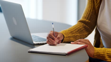 cerca de las manos de una mujer de negocios escribiendo notas en una oficina, enfoque selectivo