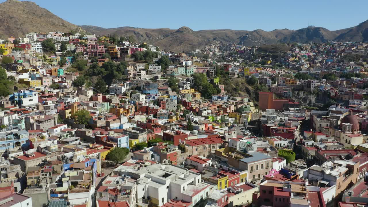 drone se eleva para revelar una colorida ciudad latinoamericana construida en las montañas, méxico