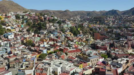 drone se eleva para revelar una colorida ciudad latinoamericana construida en las montañas, méxico