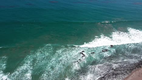 aerial, drone shot of malibu beach and pacific coast highway, overlooking houses, and crashing waves on the coast, in california, usa