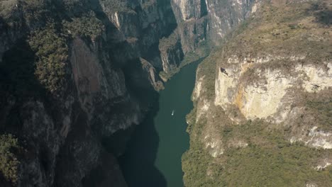 aerial top down shot of massive sumidero canyon with boat cruising on grijalva river in mexico