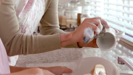 mother and daughter washing up together