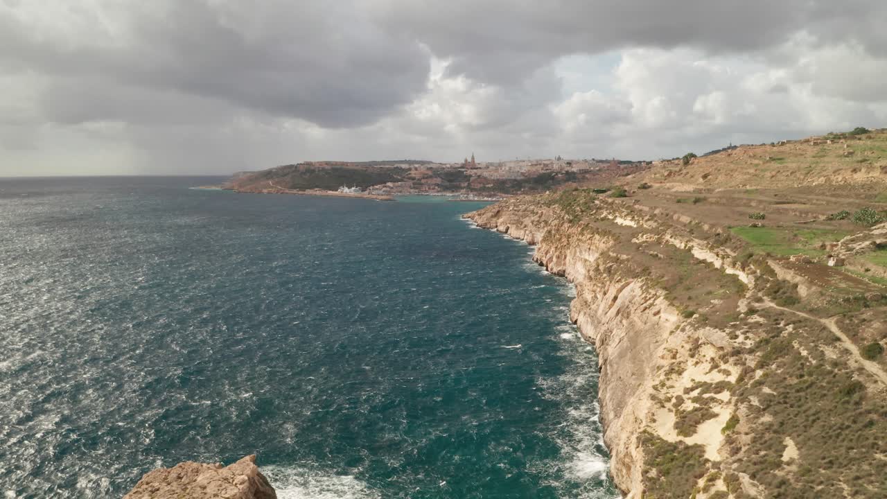 Captured by a reverse-flying aerial drone, the shot unveils Gozo's coastal ruggedness