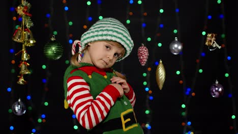 Shy-shamed-child-girl-in-Christmas-elf-Santa-helper-costume-posing-looking-camera,-feels-guilty