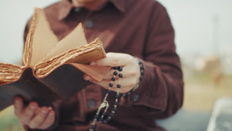 pages of the old bible book in the hands of a man praying