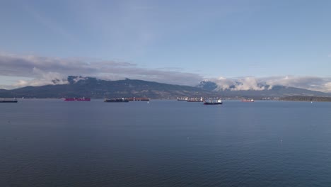 Squamish-Spit-conservation-area-Canada,-drone-aerial-view-of-cruise-boat-moored-at-harbour-with-scenic-stunning-mountains-landscape