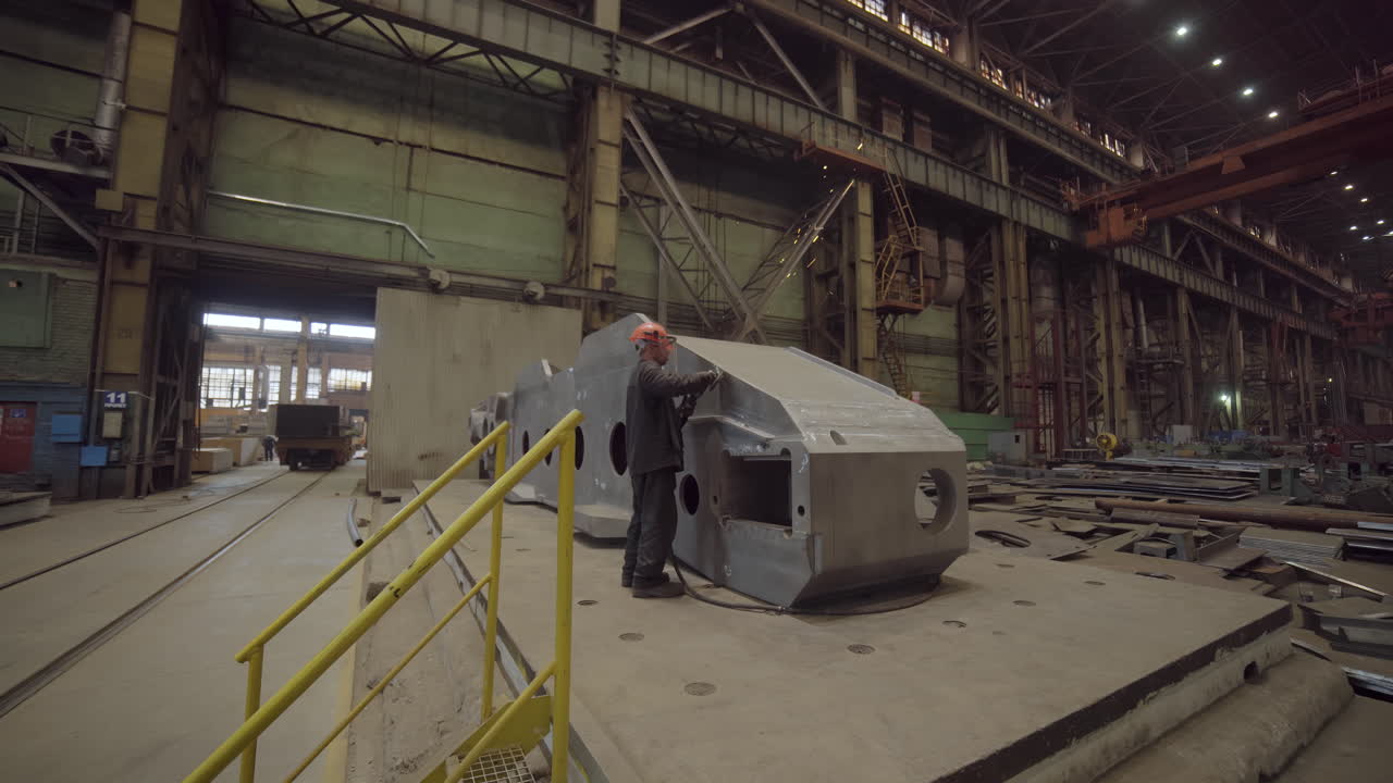 Industrial Worker Grinding Metal in a Factory