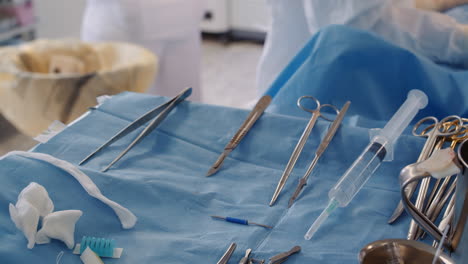 surgeon tools set on tray closeup. sterile instruments for coronary artery bypass surgery against working doctor in hospital. medical equipment