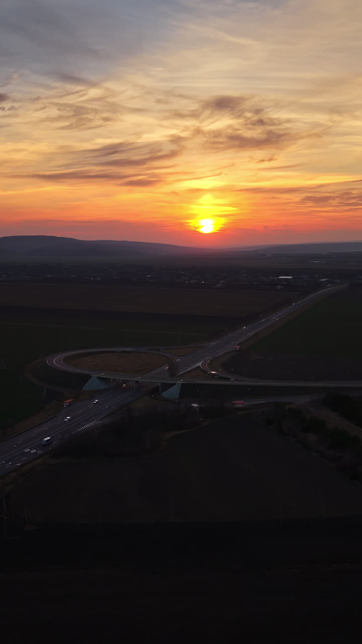 Aerial drone view of cars driving on the highway in Moldova at sunset. Vertical