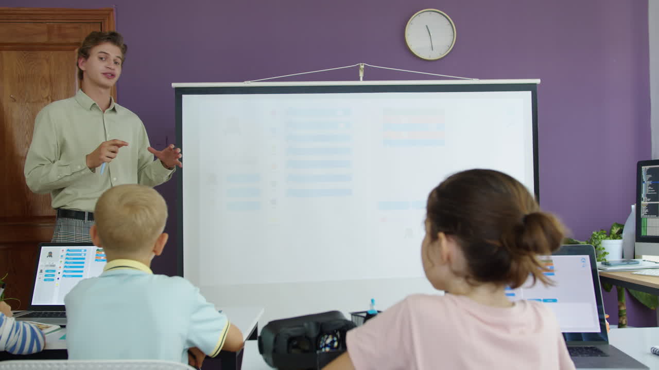 Small Students Looking at Teacher during New Topic at IT Class