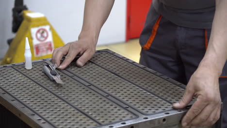 worker glues rubber seals on a metal box