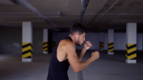 el boxeador hace shadowboxing en el estacionamiento subterráneo