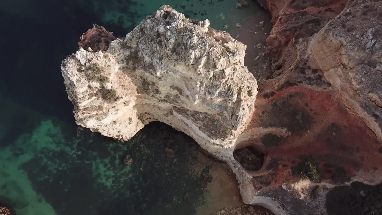 pasando sobre altos acantilados de piedra caliza en la costa del algarve en portugal, aéreo, ojo de pájaro