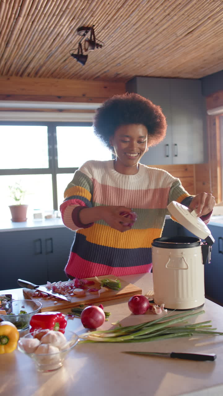 Slow-motion video shows joyful African American woman composting in kitchen