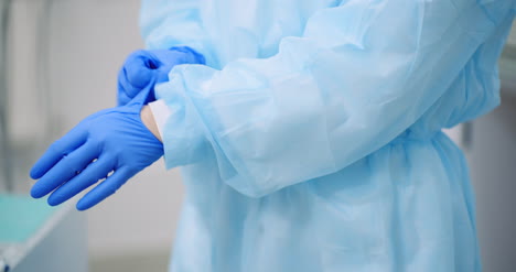 doctor puts blue protective gloves on hands at healt care clinic 4