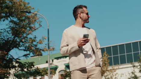 man using smartphone outdoors in city