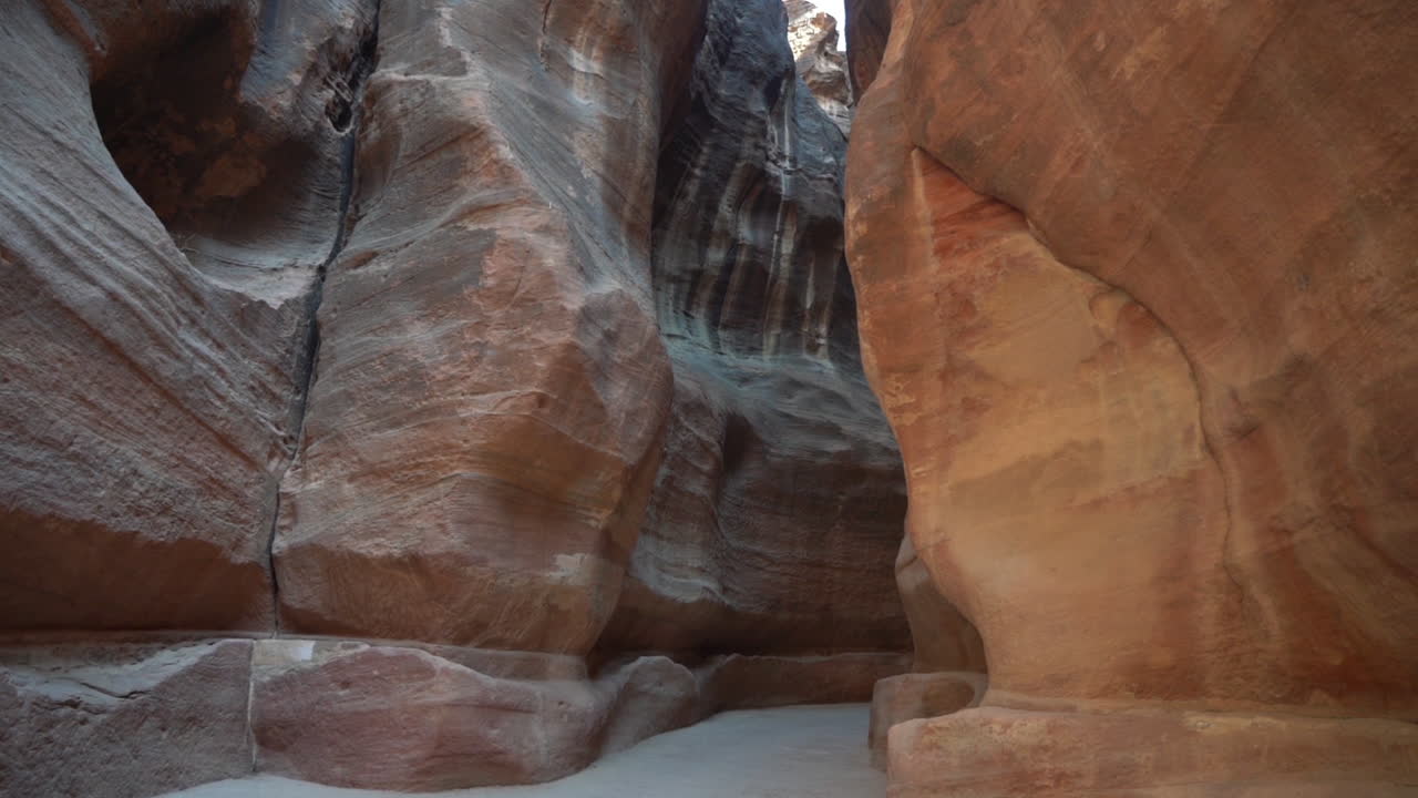 paso estrecho entre acantilados empinados, camino al templo de petra, jordania, inclinado hacia abajo
