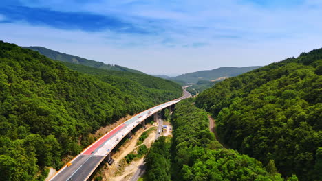 scenic highway crossing lush green hills. a highway winds through lush hills under a bright blue sky, blending nature's beauty with modern design