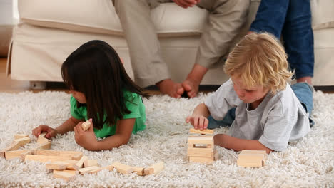 zap text on speech bubble against kids playing jenga game at home