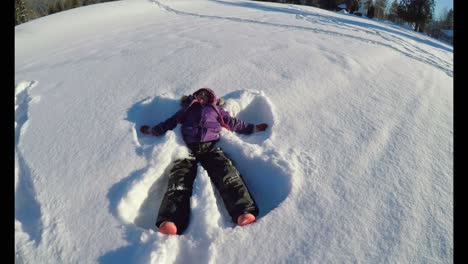 kid making snow angels in snow during winter 4k