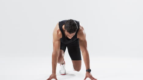 Athlete-in-starting-position-on-a-track-on-white-background