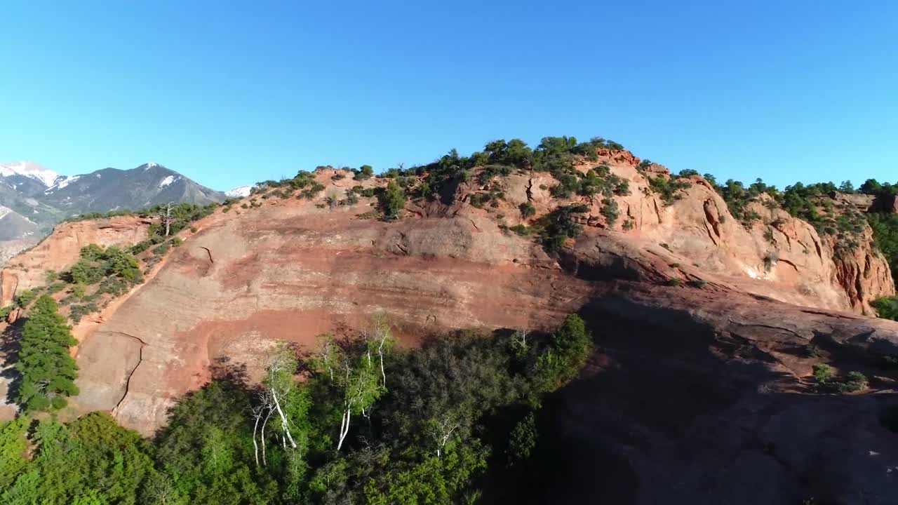 los acantilados rojos cerca de moab, utah, se alejan para revelar cielos despejados y montañas cubiertas de nieve.