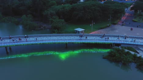 aerial view of illuminated bridge at night with people walking