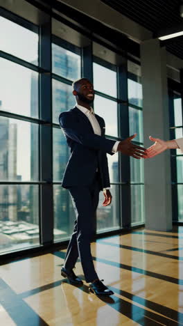 businessmen shaking hands in a modern office with city views