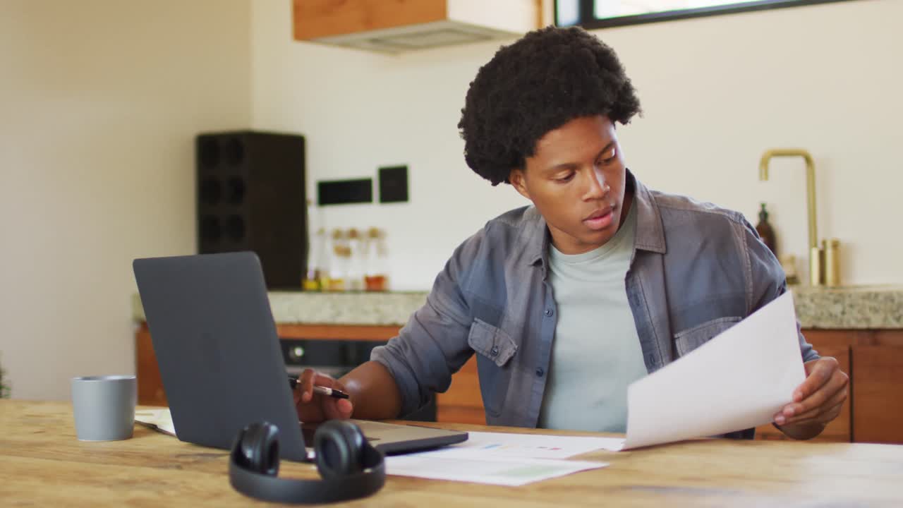 Uomo afroamericano che lavora da casa e usa il laptop