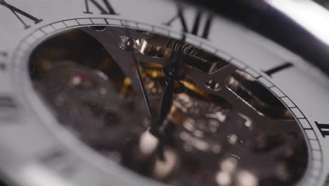 mechanical pocket watch with visible gears and hand ticking, macro, focus pull