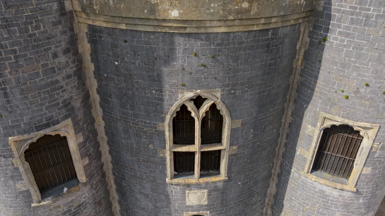 Aerial drone shot of Blaise Castle, Henbury, Bristol. Starting at ground level facing the castle front, the drone and flies up and forward, tilting down into a top-down view directly over the turrets
