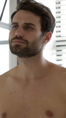 man checking his stubble in bathroom