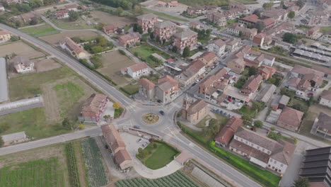 aerial footage rotating around a roundabout outside of a small town in northern italy