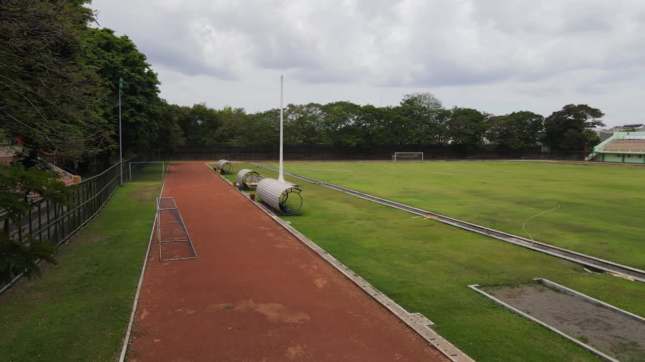달리기 트랙의 공중 드론  (aerial drone shot of a red running race track)