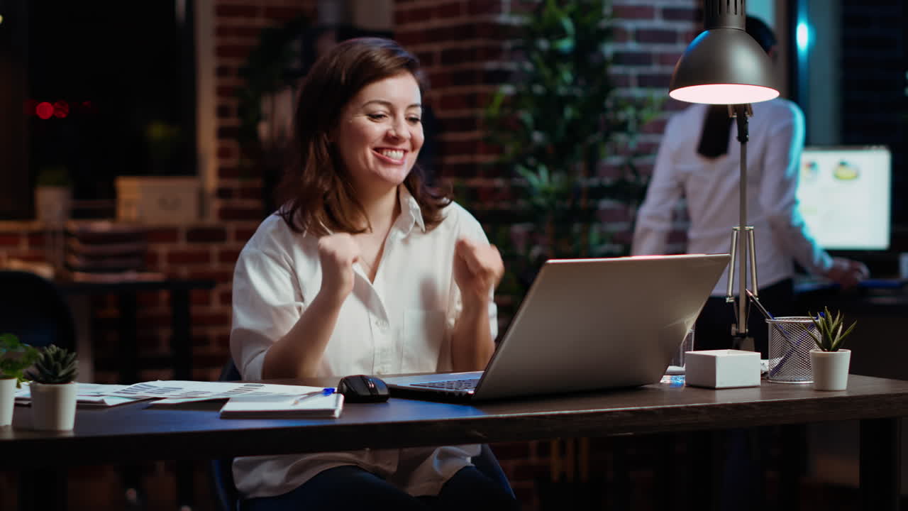 mujer en la oficina por la noche celebrando la finalización del acuerdo con socios de negocios