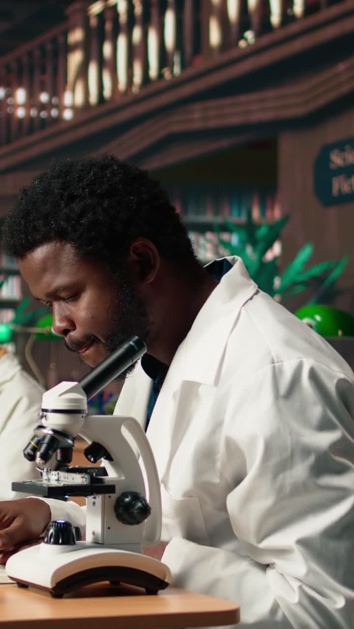 Scienziato afroamericano che usa il microscopio e sorride
